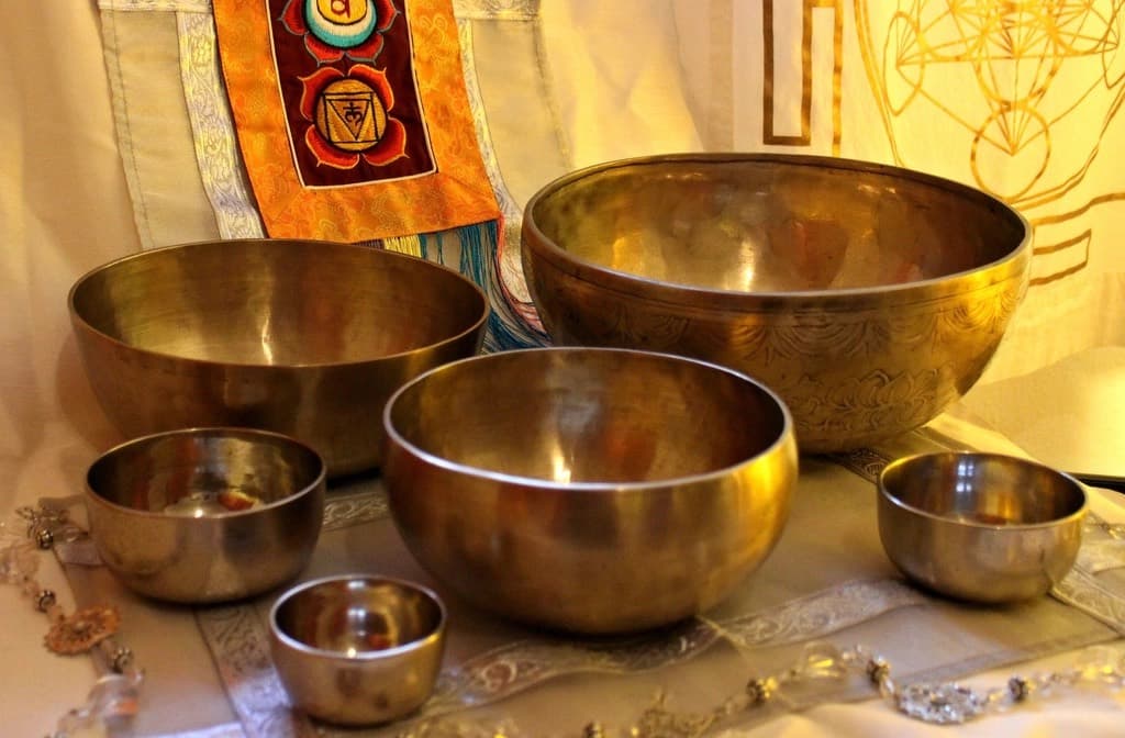 Campane tibetane e ciotole armoniche disposte per una sessione di bagno sonoro